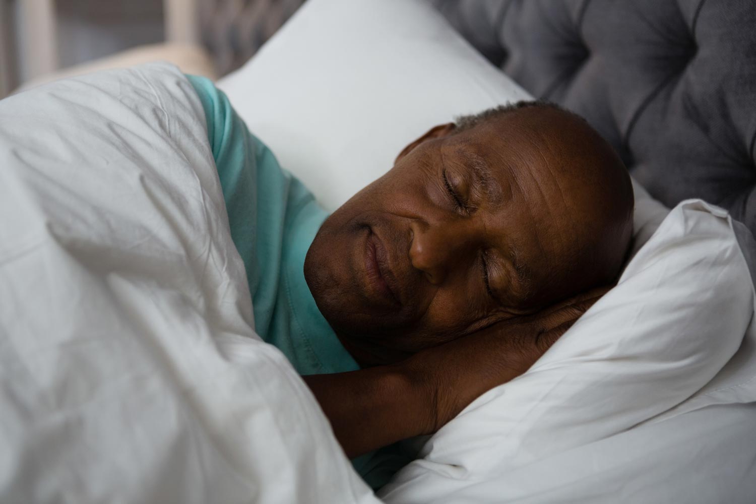 an adult male sleeping in a bed