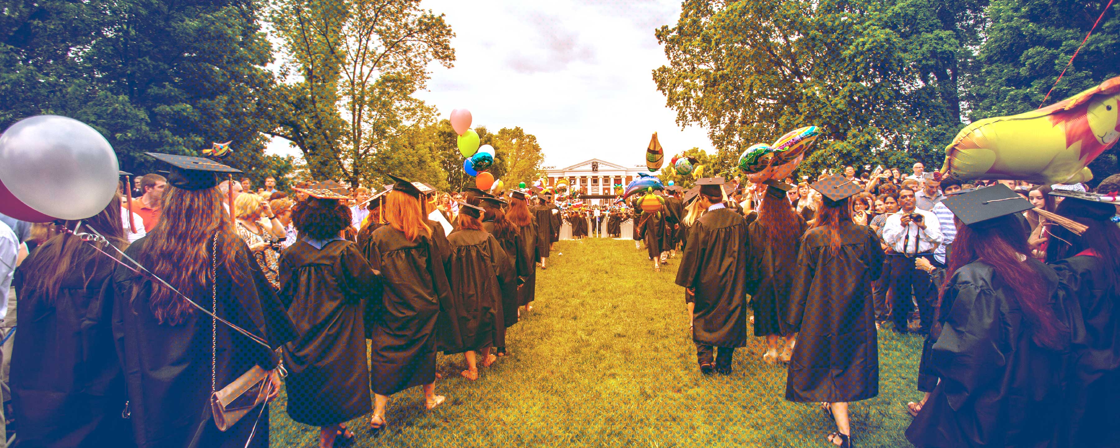 Graduates walking across the lawn from the Rotunda to their seats